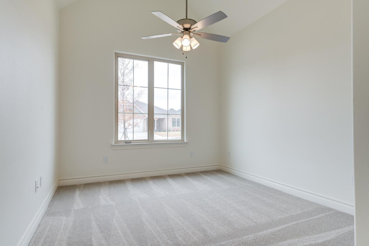 3712 144th Street Lubbock, TX 79423 - Photo 4 of 46 an empty room with a window and a fan
