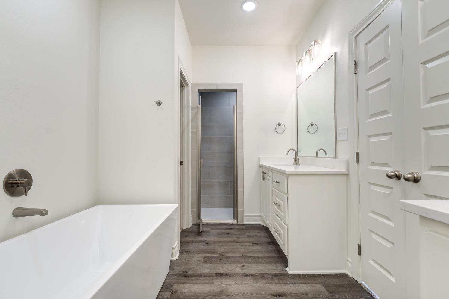 3712 144th Street Lubbock, TX 79423 - Photo 41 of 46 a bathroom with a sink a mirror and a bathtub