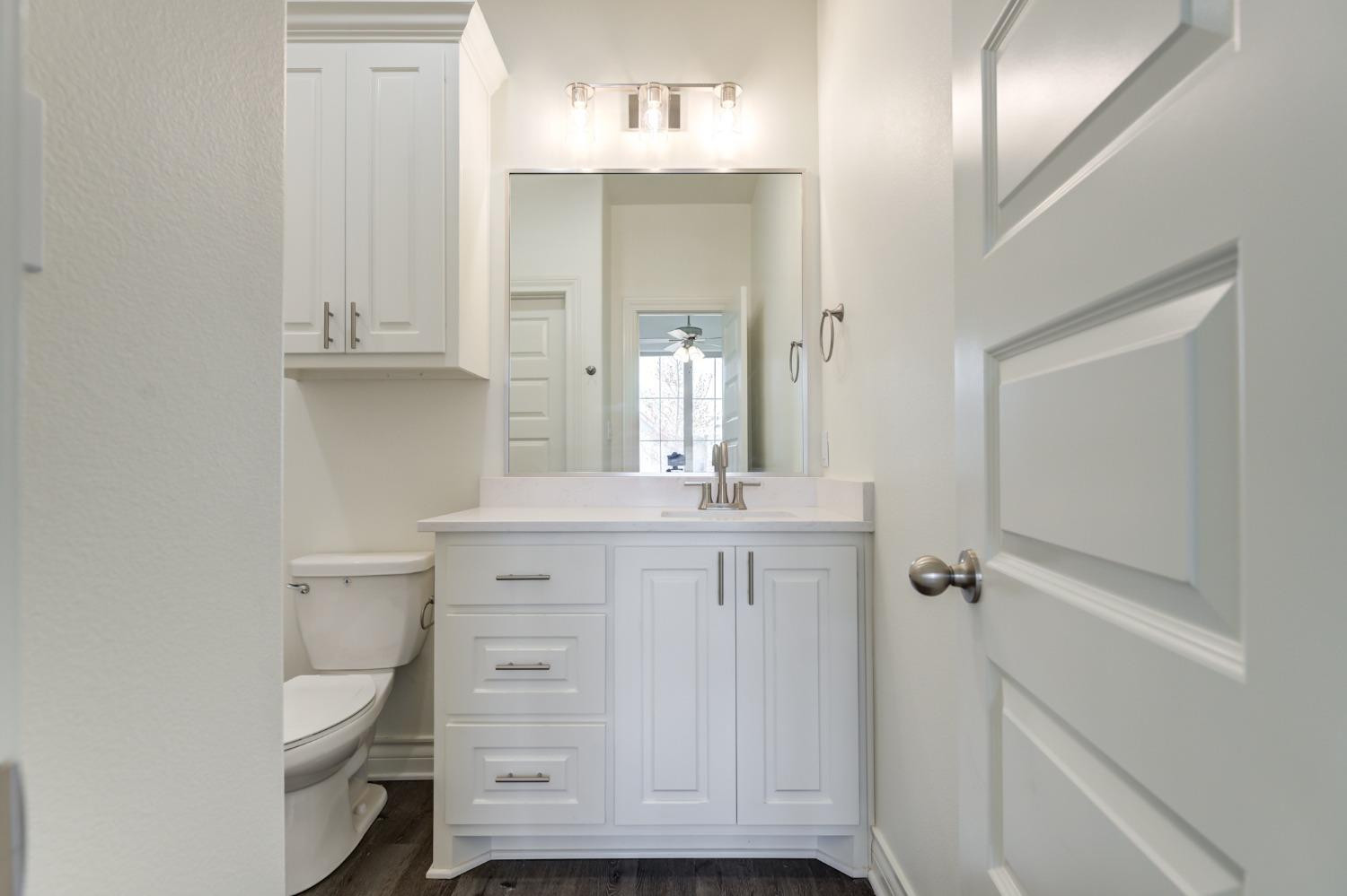 3712 144th Street Lubbock, TX 79423 - Photo 7 of 46 a bathroom with a toilet a sink and mirror
