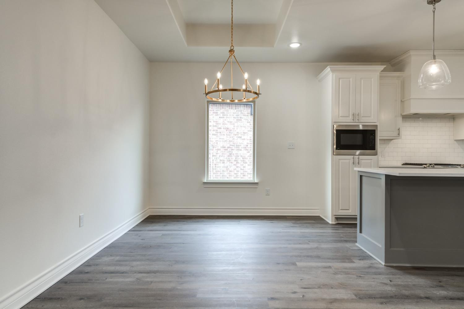 3712 144th Street Lubbock, TX 79423 - Photo 10 of 46 wooden floor in an empty room with a kitchen