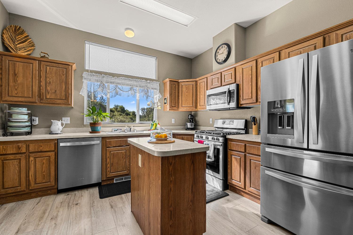 9425 Mosquito Road Placerville, CA 95667 - Photo 28 of 74 a kitchen with stainless steel appliances granite countertop a refrigerator a sink dishwasher a stove and white countertops with wooden floor