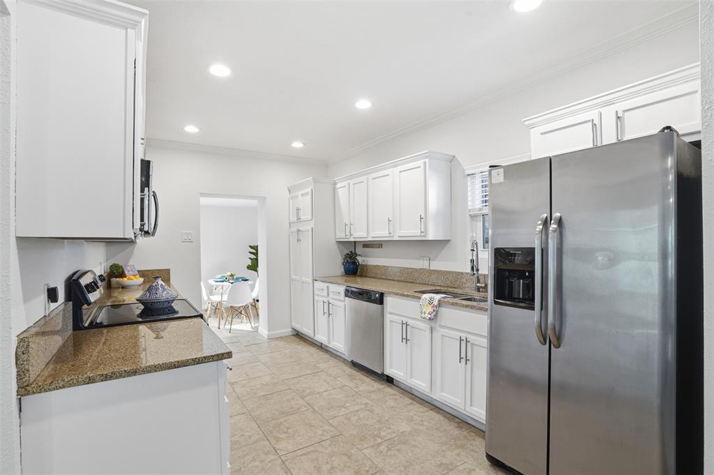 1102 Brunner Avenue Dallas, TX 75224 - Photo 17 of 38 a kitchen with white cabinets and stainless steel appliances