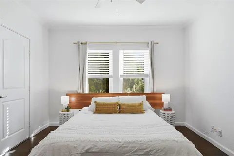 a bedroom with bed and wooden floor