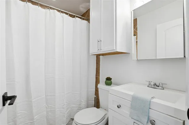 a bathroom with a sink toilet and shower