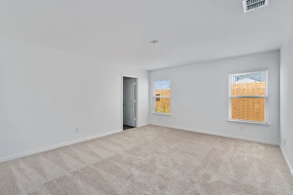 an empty room with windows and mirror