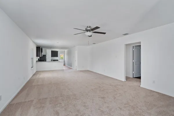 a view of a big room with chandelier fan and windows