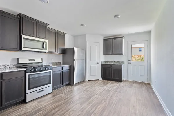 a kitchen with a stove a sink and a microwave