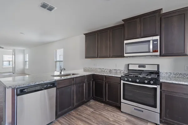 a kitchen with granite countertop a sink and stove top oven