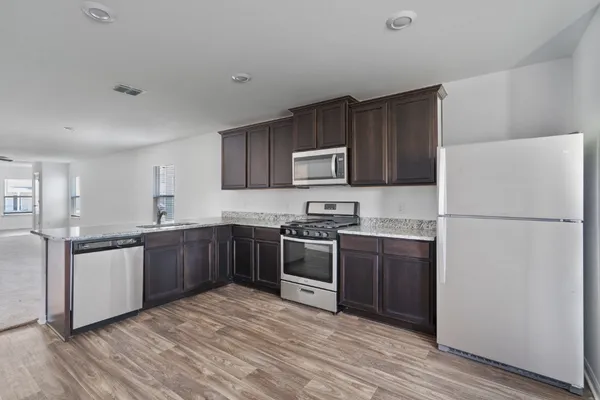 a kitchen with stainless steel appliances granite countertop a refrigerator stove and sink
