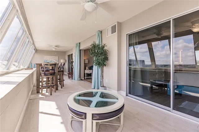 a dining room with furniture and a floor to ceiling window