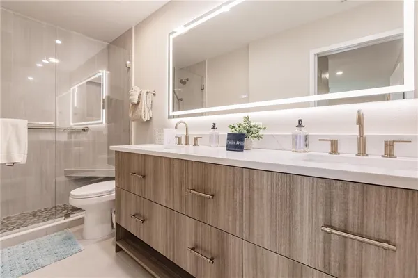a bathroom with a double vanity sink mirror and toilet