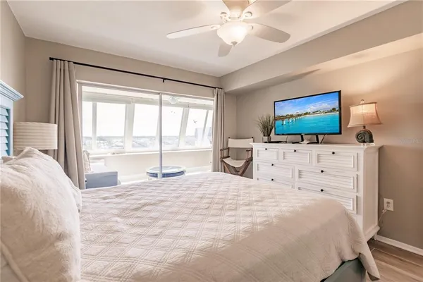 a large bedroom with a large bed and flat tv screen on dresser