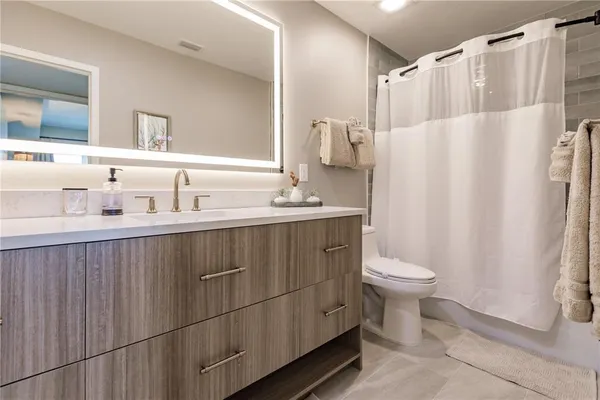 a bathroom with a sink a toilet and shower