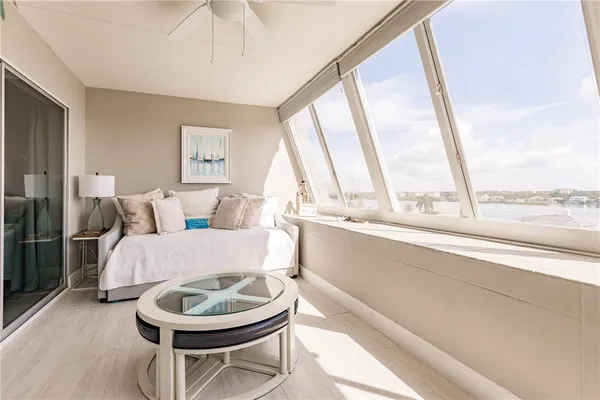 a living room with a bed and a large window