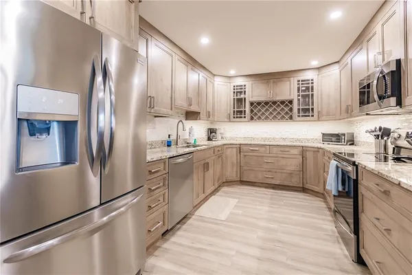 a kitchen with stainless steel appliances a refrigerator sink and cabinets