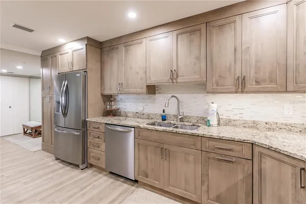 a kitchen with stainless steel appliances granite countertop a refrigerator sink and cabinets