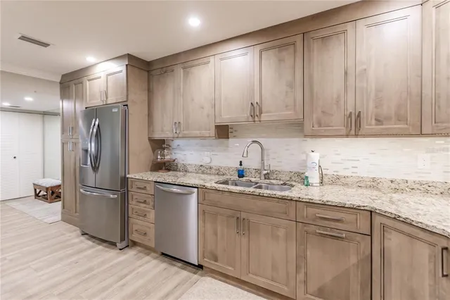 a kitchen with stainless steel appliances granite countertop a refrigerator sink and cabinets