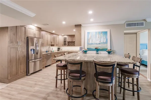a kitchen with a table chairs refrigerator and cabinets