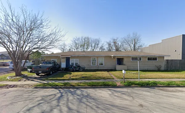 a view of a house with a big yard and large tree