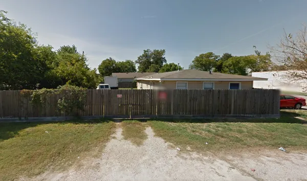 a view of backyard with potted plants and wooden fence