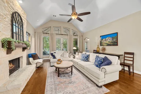 a living room with furniture a fireplace and a chandelier