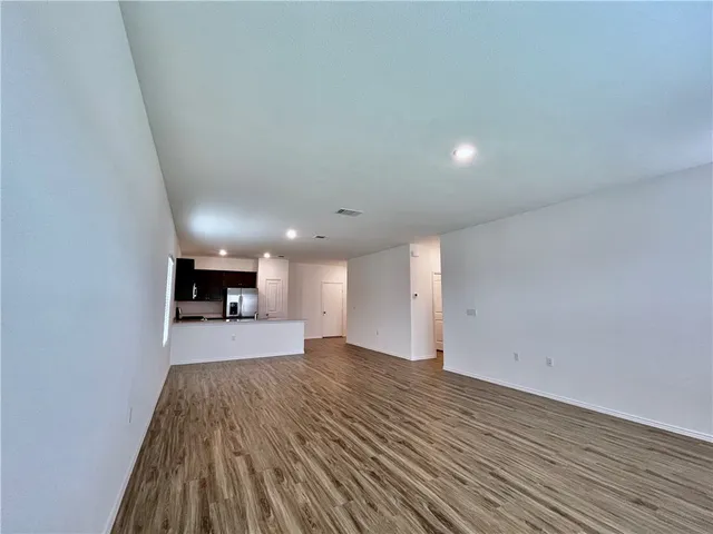 a view of a big room with wooden floor and fireplace