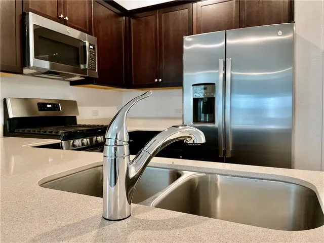 a kitchen with a refrigerator a microwave and sink