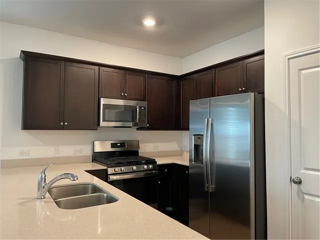 a kitchen with a refrigerator sink and stove