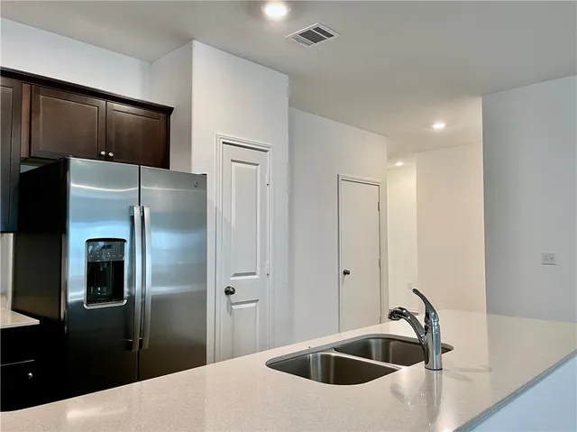 a kitchen with kitchen island a refrigerator sink and stove