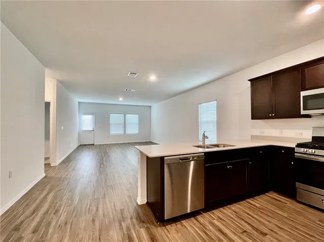 a kitchen with a sink and wooden floor