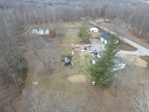 a view of a house with backyard and trees in the background
