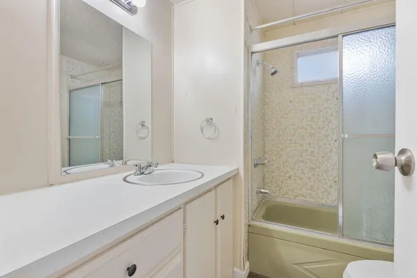 a bathroom with a granite countertop sink a toilet and shower