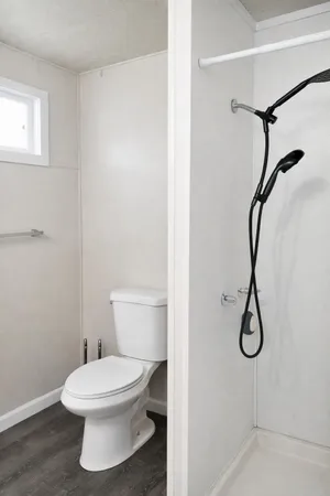 a white toilet sitting next to a shower