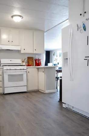 a kitchen with cabinets a sink and white appliances