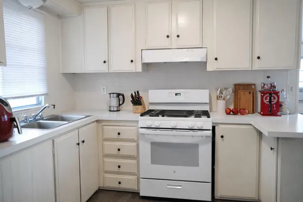 a kitchen with cabinets appliances a sink and a counter top