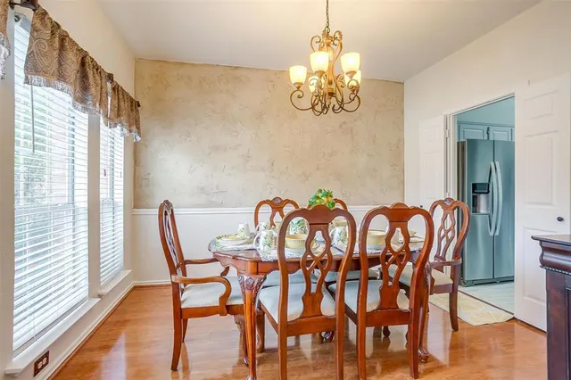 a view of a dining room with furniture a chandelier and wooden floor