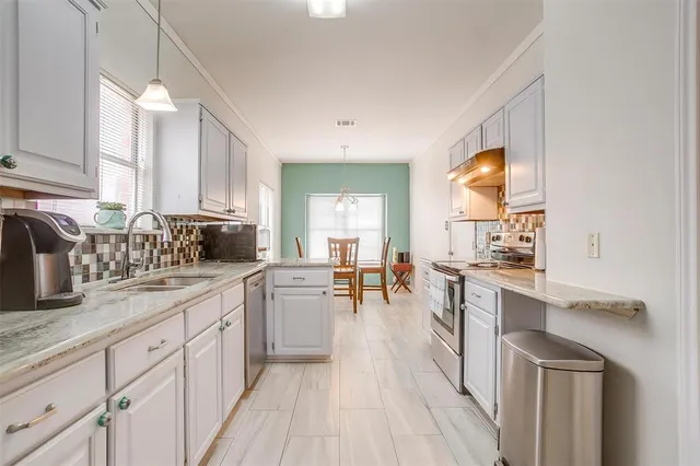 a kitchen with sink stove and cabinets