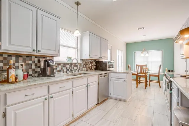 a kitchen with white cabinets and sink
