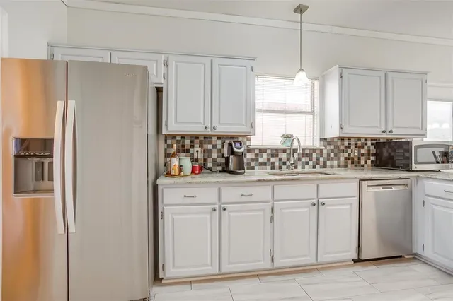 a kitchen with white cabinets and refrigerator