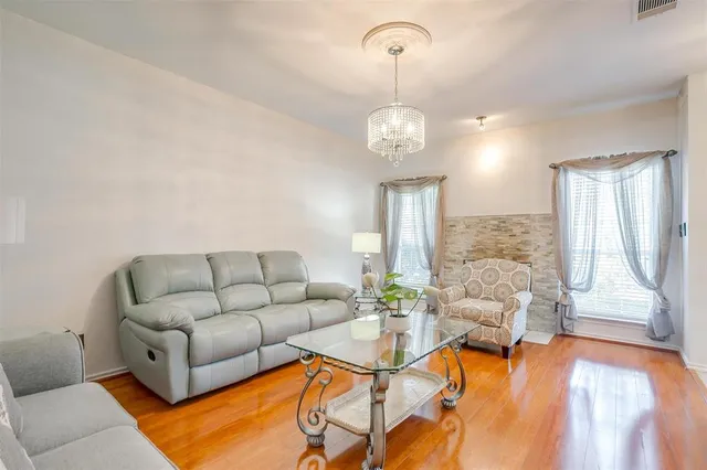 a living room with furniture wooden floor and a chandelier