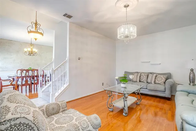 a living room with furniture a dining table and a chandelier