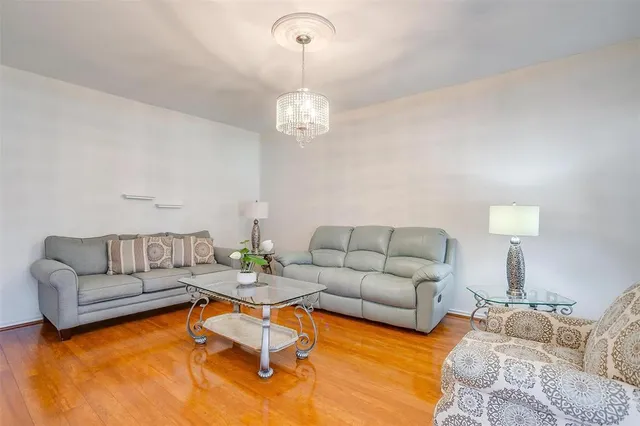a living room with furniture chandelier and view of kitchen