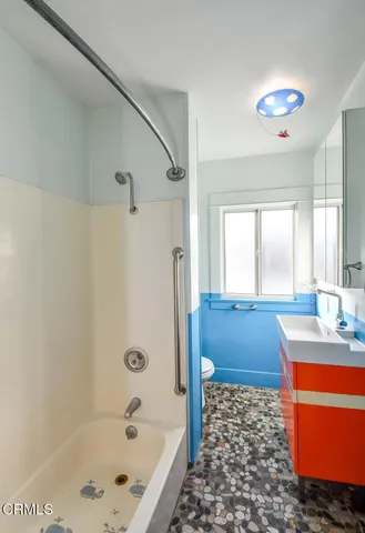 a bathroom with a bathtub sink and mirror