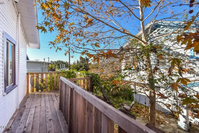 a view of a balcony with wooden floor and fence
