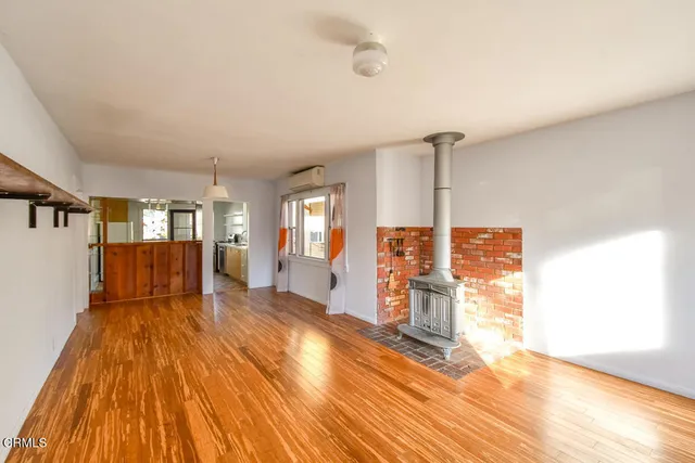 a spacious bedroom with a bed and wooden floor