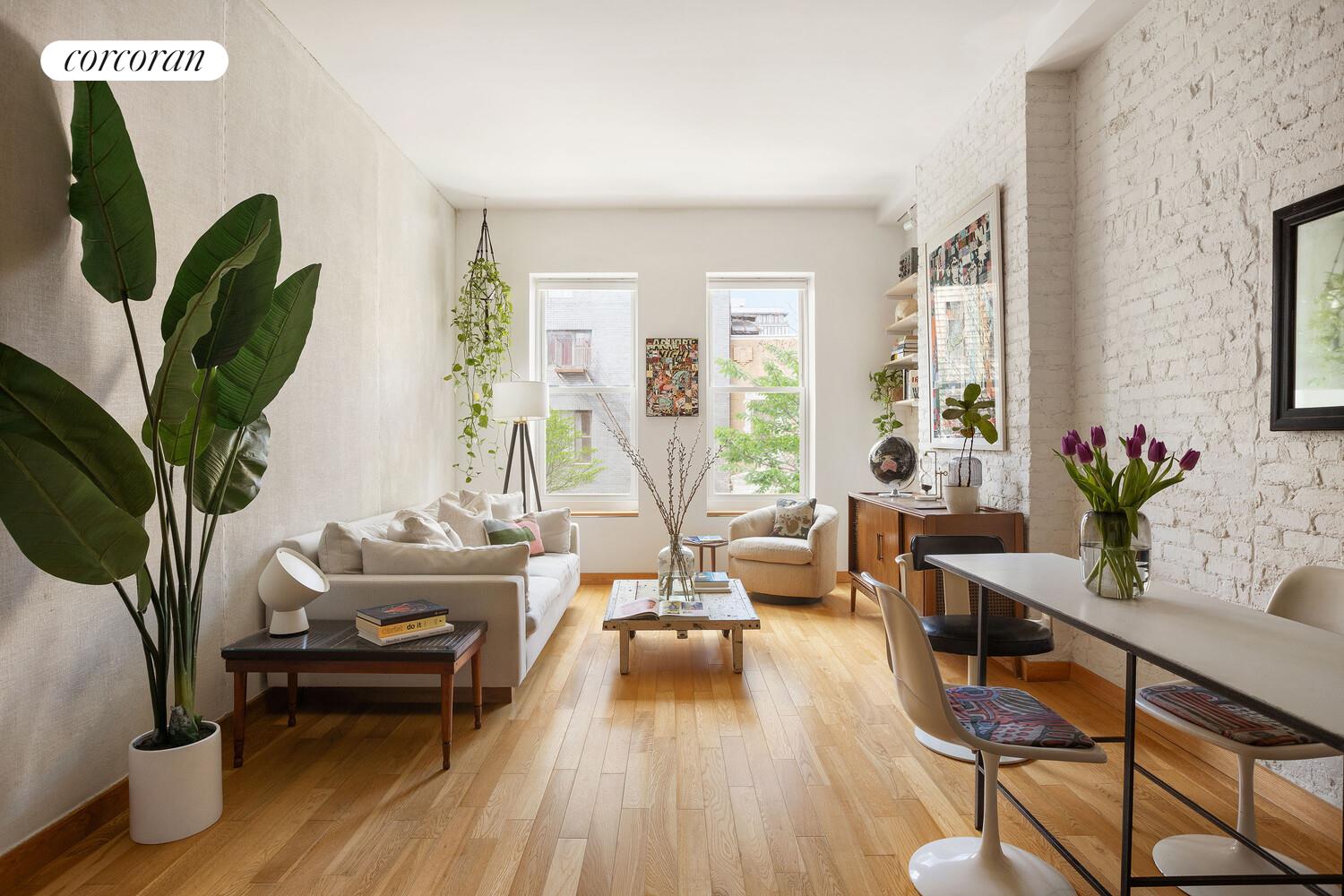 a living room with furniture a potted plant and a large window