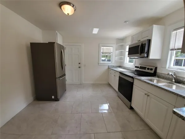 a kitchen with a sink stove and microwave