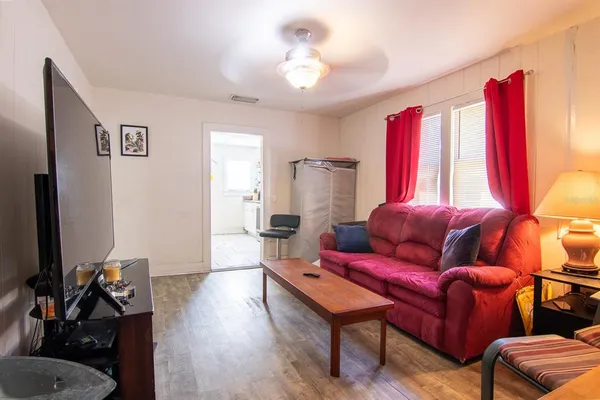 a living room with furniture a flat screen tv and a window