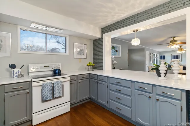 a view of cabinets a sink and dishwasher stove with wooden floor