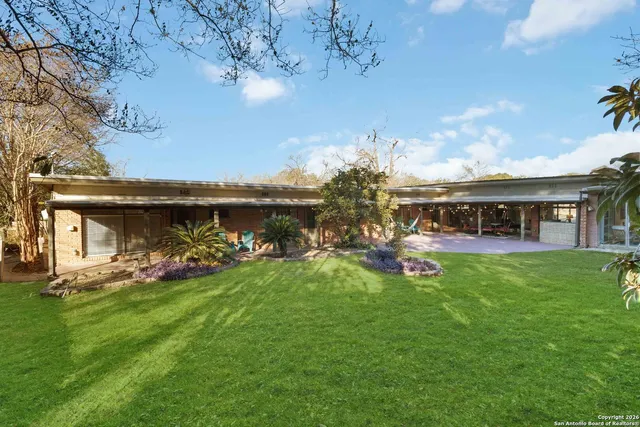a view of a house with a big yard and potted plants